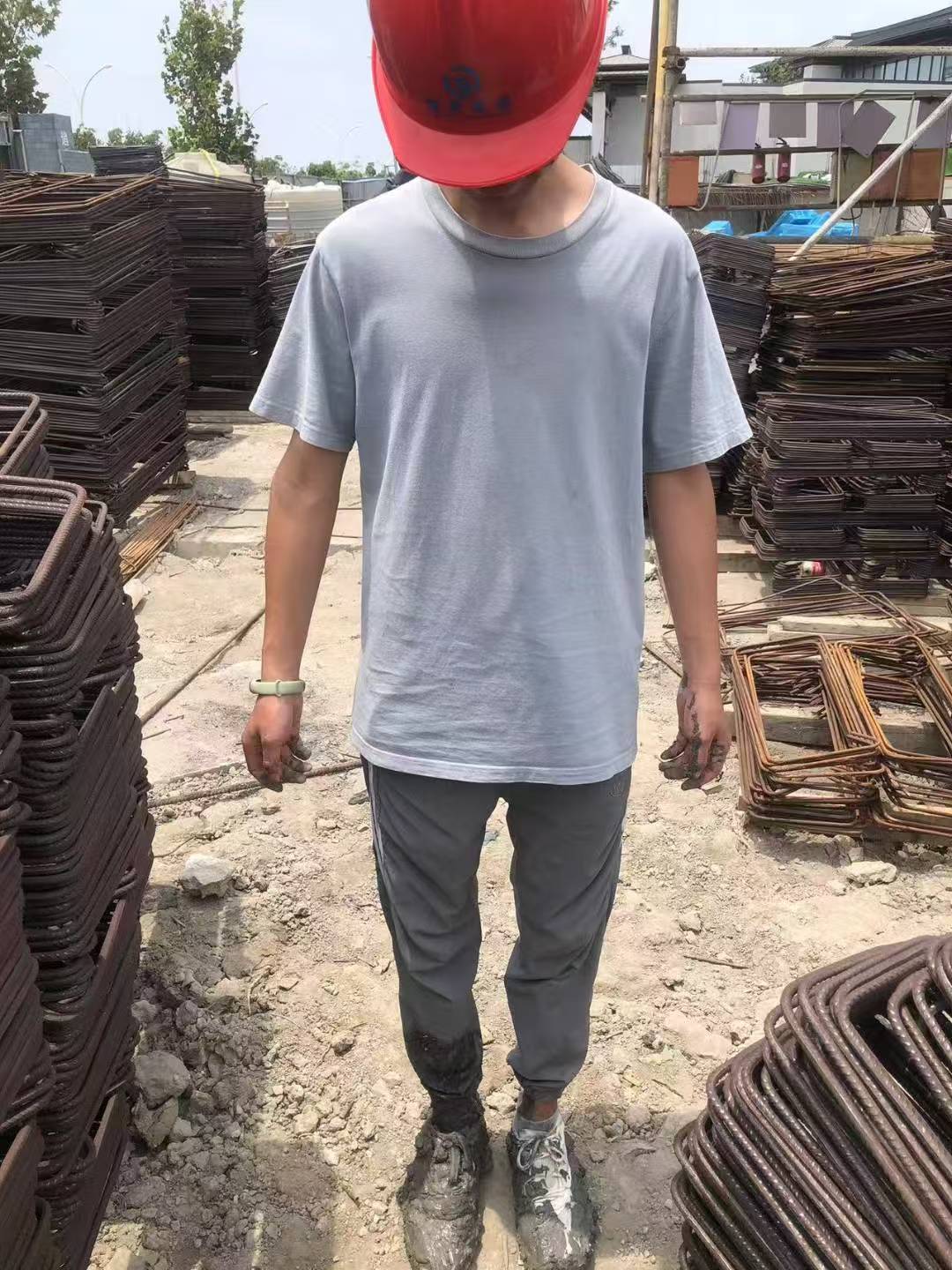曾经在工地的小北，戴红色安全帽，站在钢筋之间